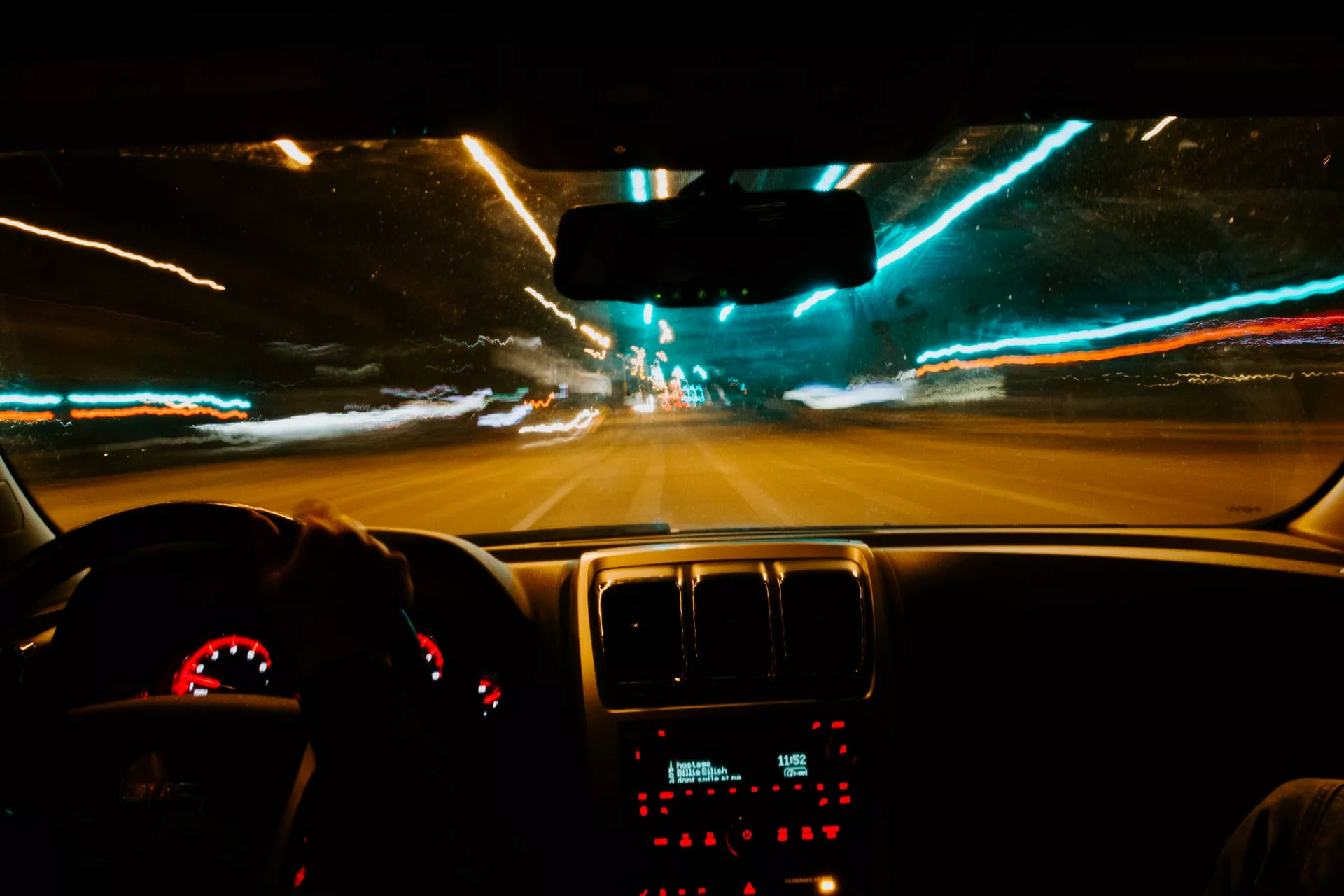 Blick auf Autobahn durch Windschutzscheibe bei Nacht, alles ist verschwommen