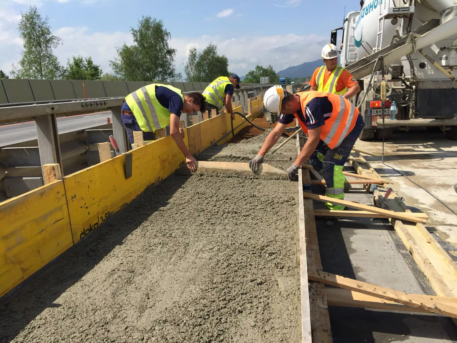 Vier Bauarbeiter arbeiten an einer Baustelle mit Beton