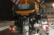 Oranger Lkw mit sieben Kubikmeter Fassungsvermögen für Trockensalz und 3.400 Liter Salzsole bei Nacht