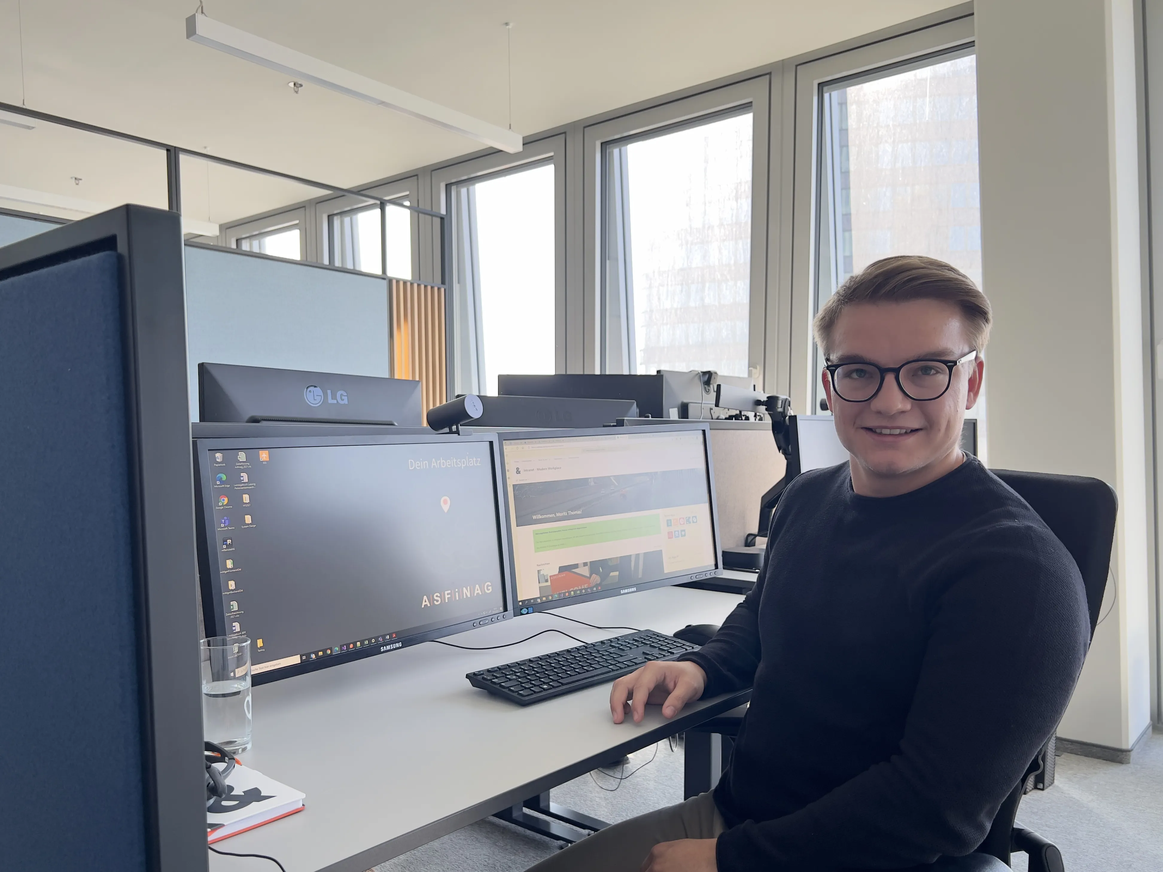 Ein Mann sitzt vor mehreren Bildschirmen an einem Schreibtisch