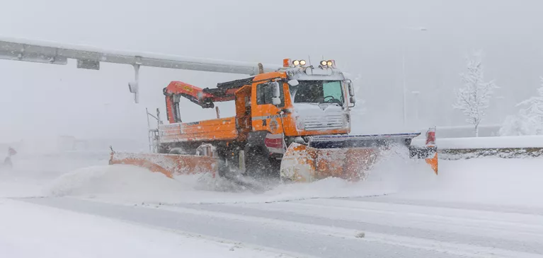 ASFINAG Schneepflug auf verschneiter Autobahn