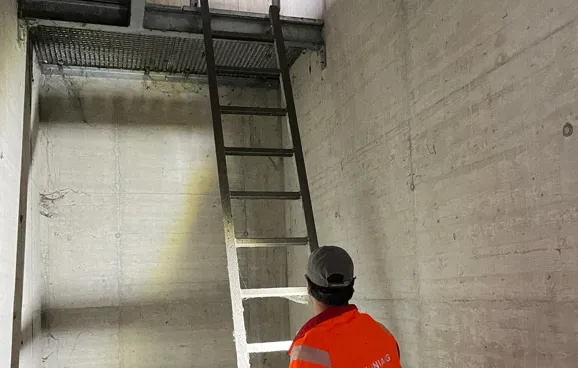 Fritz steigt im Inneren der Brücke eine Leiter hinauf.