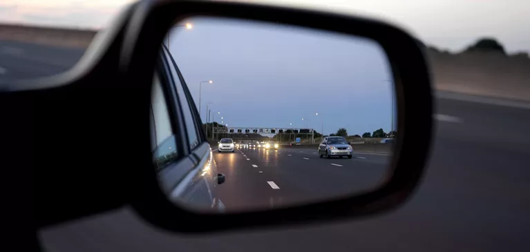 Blick auf die Autobahn durch einen Rückspiegel