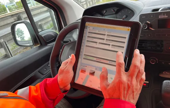 Fritz sitzt wieder im Fahrzeug und macht Notizen in seinem Tablet.