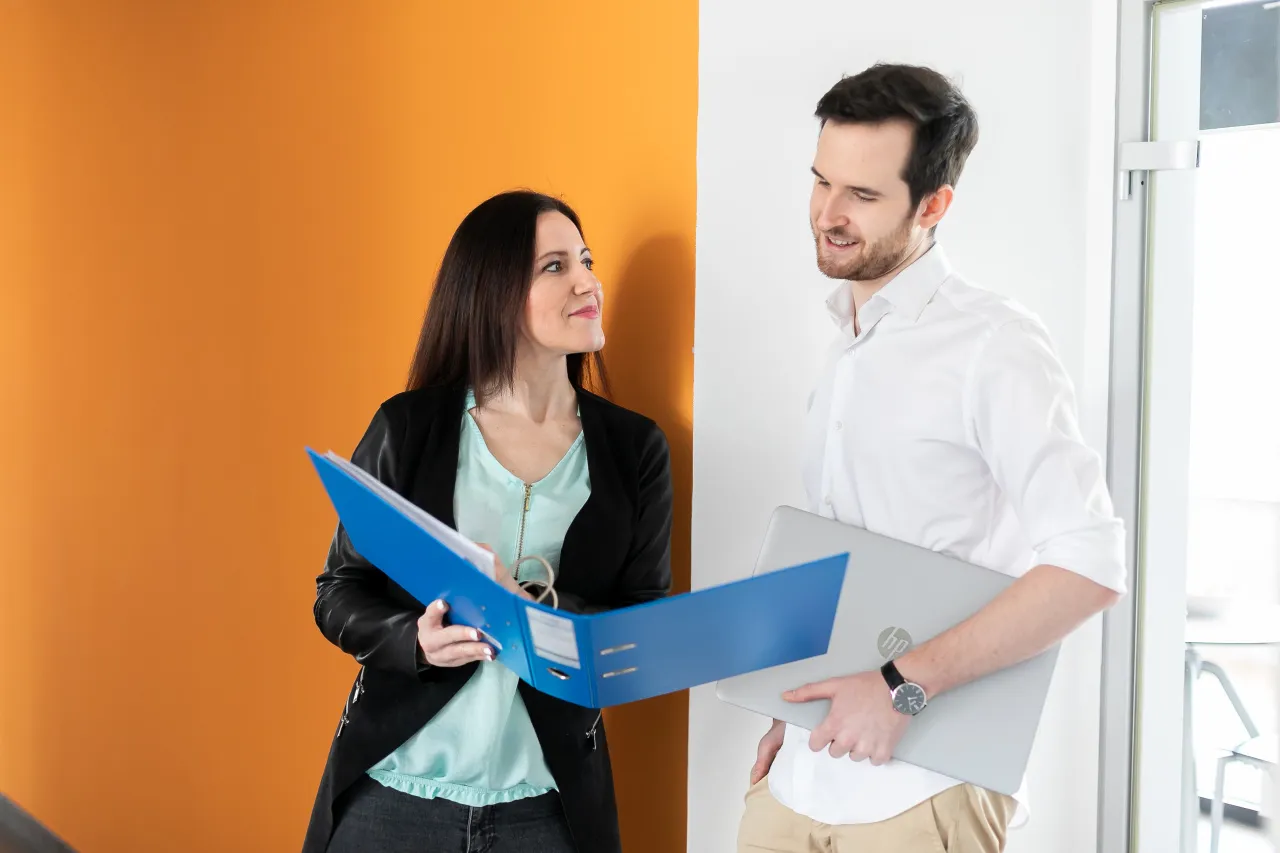 Ein Mann und eine Frau schauen in eine Mappe