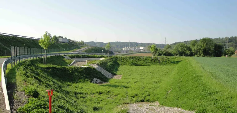 Eine Gewässerschutzanlage, die schon mit Wiese überwachsen ist. Man sieht sie kaum.