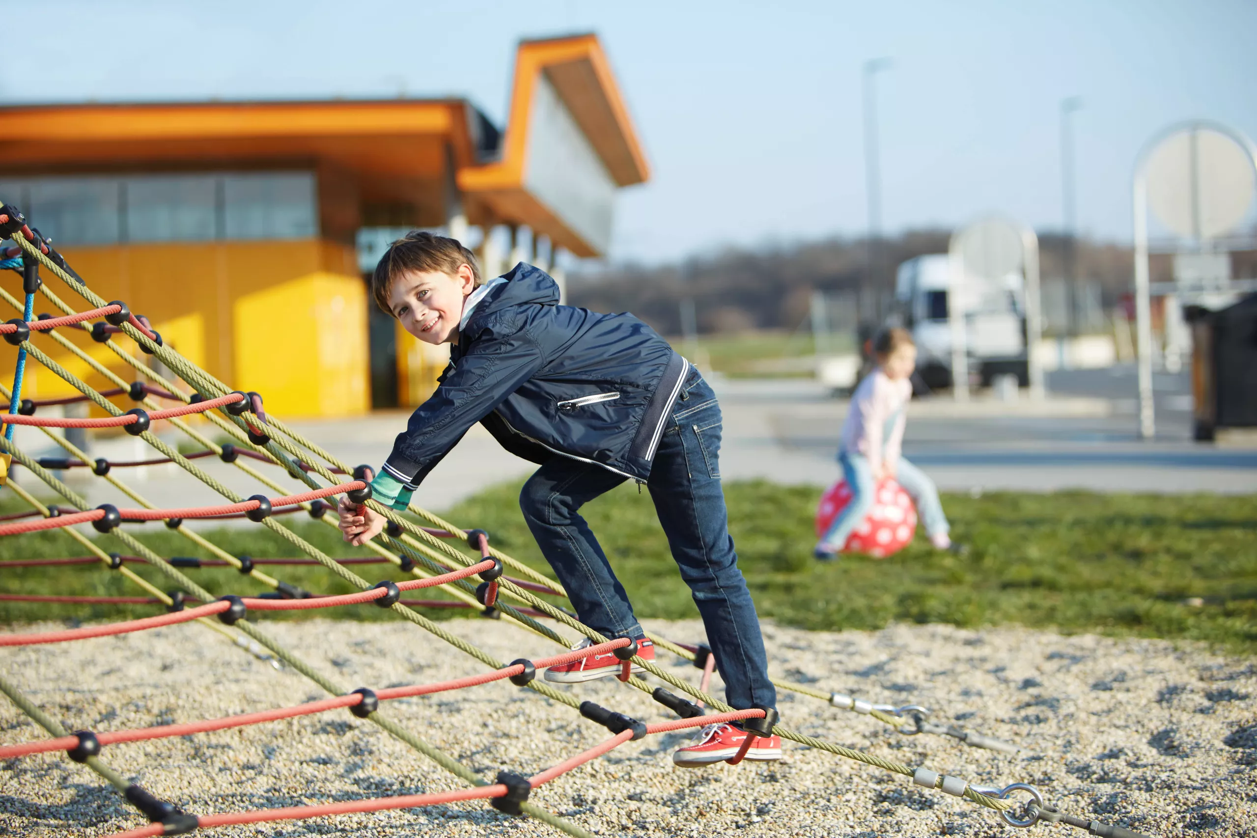 Ein Kind klettert auf einem Netz auf einem ASFINAG Rastplatz Kinderspielplatz
