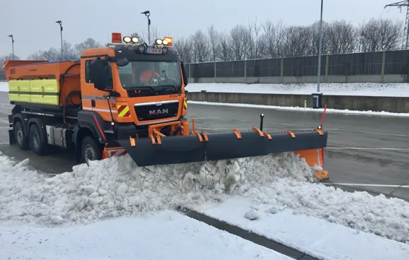 Schneepflug räumt Parkplatz