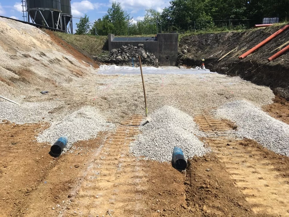Neuaufbau des Bodenfilters: Hier ist die Drainageschicht mit neuen Drainagerohren beim Bau einer Gewässerschutzanlage zu sehen.